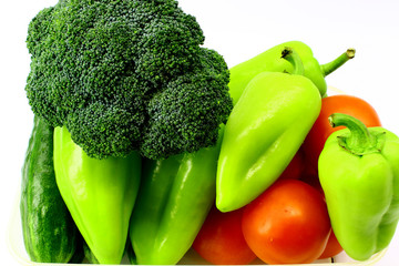 Green cucumbers, red tomatoes, broccoli, sweet green peppers on white background