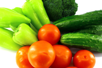 Green sweet peppers, cucumbers, broccoli, red tomatoes on white background