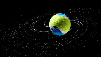 tennis ball with water drops in a spiral on a dark background