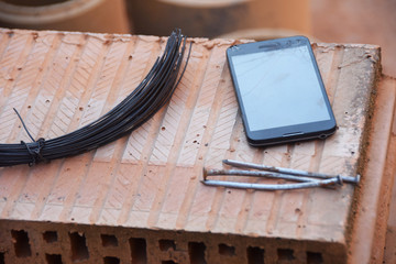 a bunch of steel reinforcing wires and a bricklayer's cell phone