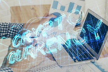 Crypto currency theme hologram with businessman working on computer on background. Concept of blockchain. Double exposure.