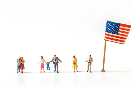selective focus of miniature people , couple , and family  with United State flag isolated on white background, creative image for 4 July independent day celebrate concept.