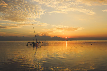 Sunrise view at Sanur Beach, Bali island, Indonesia. Traditional Balinese jukung fishing boats