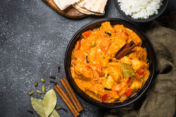 Chicken tikka masala with rice on black top view.