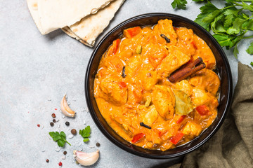 Chicken tikka masala with rice on black top view.