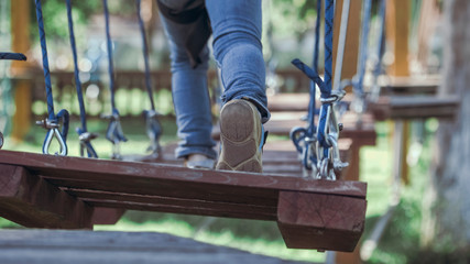 Cute preschool girl in climbing gear in a rope park, family outdoor activities, happy summer time, sports and an active lifestyle