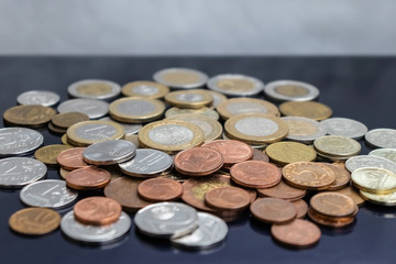 A bunch of coins from different countries on a blue background.