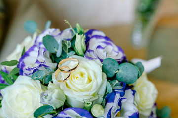 wedding rings lie and beautiful bouquet as bridal accessories