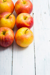 apple fruits in a row, white wooden table background