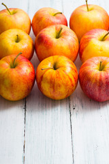 apple fruits in a row, white wooden table background