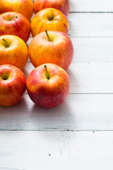 apple fruits in a row, white wooden table background