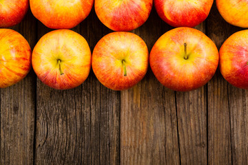 apple fruits in a row, old weathered wood table background