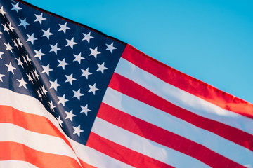 Obraz premium American flag in a blue sky, close up. Symbol of Independence Day fourth of July in USA