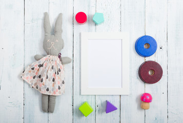 white empty picture frame illustration copy space, homemade rabbit doll, wooden background