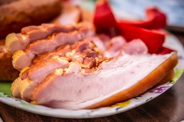Close up of raw bacon, sausages and paprika on colorful tray, prepared for barbecue