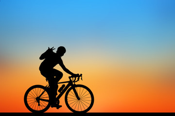 Silhouette man  and bike relaxing on blurry sunrise  sky   background.
