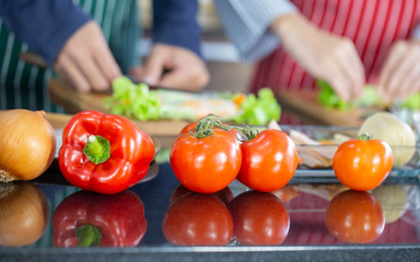 Red Tomato and Bell Pepper on table with lover cooking background