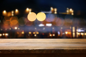 background of wooden table in front of abstract blurred restaurant lights