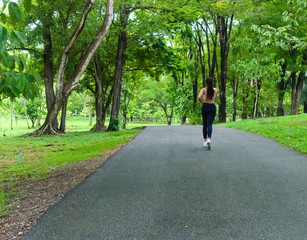 young girl doing jogging in tropical park. Healthy lifestyle concept