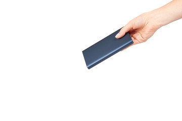 Hand with dark blue power bank for charging mobile devices, external battery.