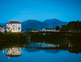 Obraz premium Warm street lamps lights a building with mountains and countryside on the background