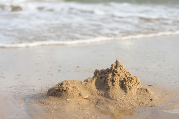 Sand castles destroyed by sea water But the remains of the ruined soil Summer concept Unsustainable and uncertain