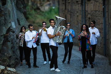 Group of Jazz musicians with wind instruments playing on the street.