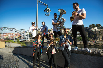 Group of Jazz musicians with wind instruments playing on the street.