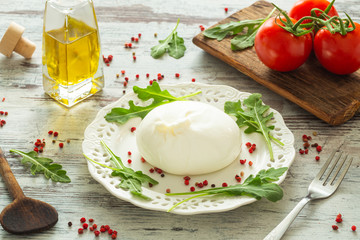 Burrata, Italian cheese with tomatoes, spices, argugula and olive oil and balsamic vinegar