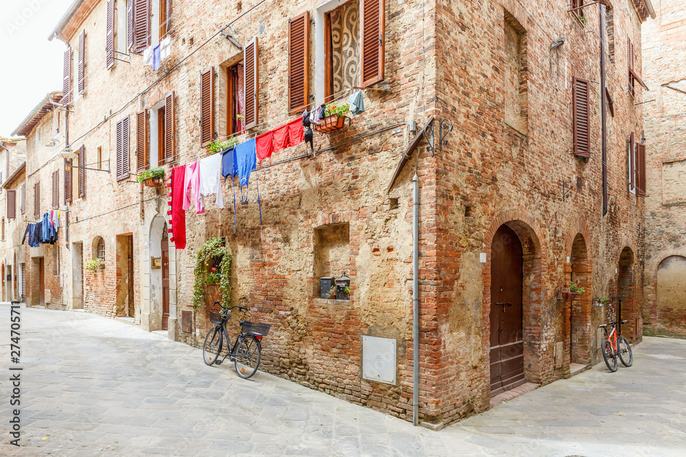 Poster Italian alleyway with hanging laundry and parked bicycles