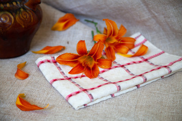 orange lily flowers in vintage vase on gray background