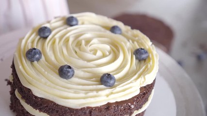 confectioner spreads a layer of berries on a cream of the cake, the inner layer