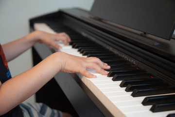 Fototapeta na wymiar a child learns to play a good piano