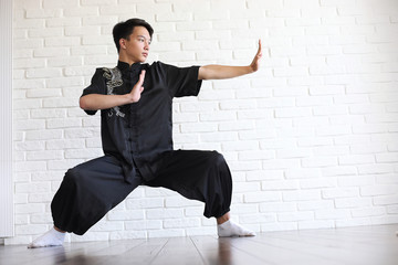 Asian young novice on a white brick wall