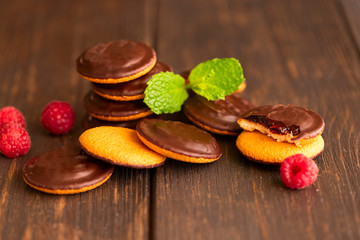 Jaffa cakes, cookies covered with dark chocolate and filled with raspberry marmalade. Sweet background.
