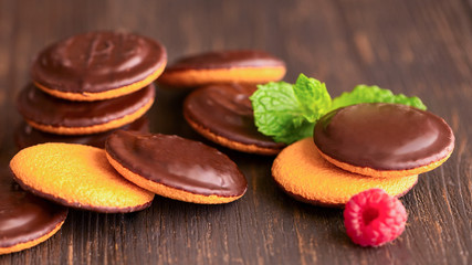 Jaffa cakes, cookies covered with dark chocolate and filled with raspberry marmalade. Sweet background.