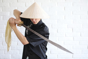 Asian young novice on a white brick wall