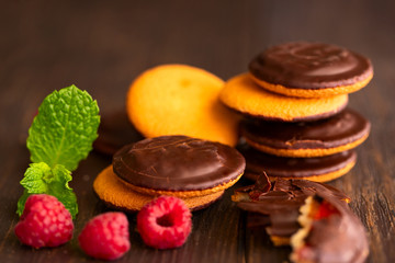 Jaffa cakes, cookies covered with dark chocolate and filled with raspberry marmalade. Sweet background.