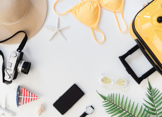 top view travel concept with bikini, luggage, retro camera and Outfit of traveler on white wooden background, Tourist essentials, vintage tone effect
