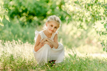 Preschool girl sitting on the grass