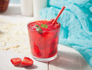 Glass with fresh homemade strawberry sweet iced tea or cocktail, lemonade with mint. Refreshing cold drink. Summer pool party. Marine theme.
