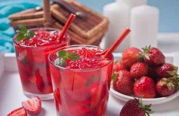 Glasses with fresh homemade strawberry sweet iced tea or cocktail, lemonade with mint. Refreshing cold drink. Summer pool party. Marine theme.
