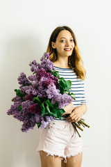 Attractive girl with a violet bouquet of lilac on a white background