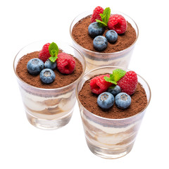 Classic tiramisu dessert with blueberries and raspberries in a glass isolated on a white background with clipping path