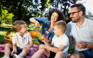 Happy young family enjoying picnic in nature