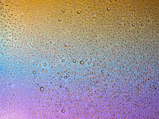 Water droplets on the glass with a colored background. Drops of water.