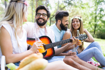 Happy young friends having picnic in the park