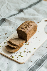 fresh sliced bread on a wooden board on a grey fabric