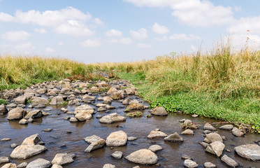 Shallow  river flowing near the remnants of the early Bronze Age megalithic complex of the early Bronze Age  - Wheels of Spirits - Rujum Al-Hiri - Gilgal Rephaeem - on the Golan Heights in Israel