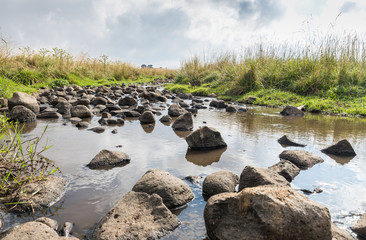 Shallow  river flowing near the remnants of the early Bronze Age megalithic complex of the early Bronze Age  - Wheels of Spirits - Rujum Al-Hiri - Gilgal Rephaeem - on the Golan Heights in Israel